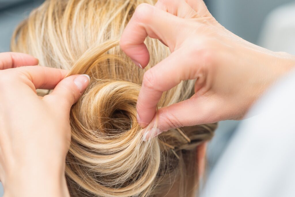 Elegante Hochsteckfrisur mit voluminösem, geflochtenem Kranz im Nacken.