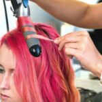 Stylen von Locken mit dem Lockenstab in trendiger Pink-Haarfarbe, Friseur Belissima Krems.