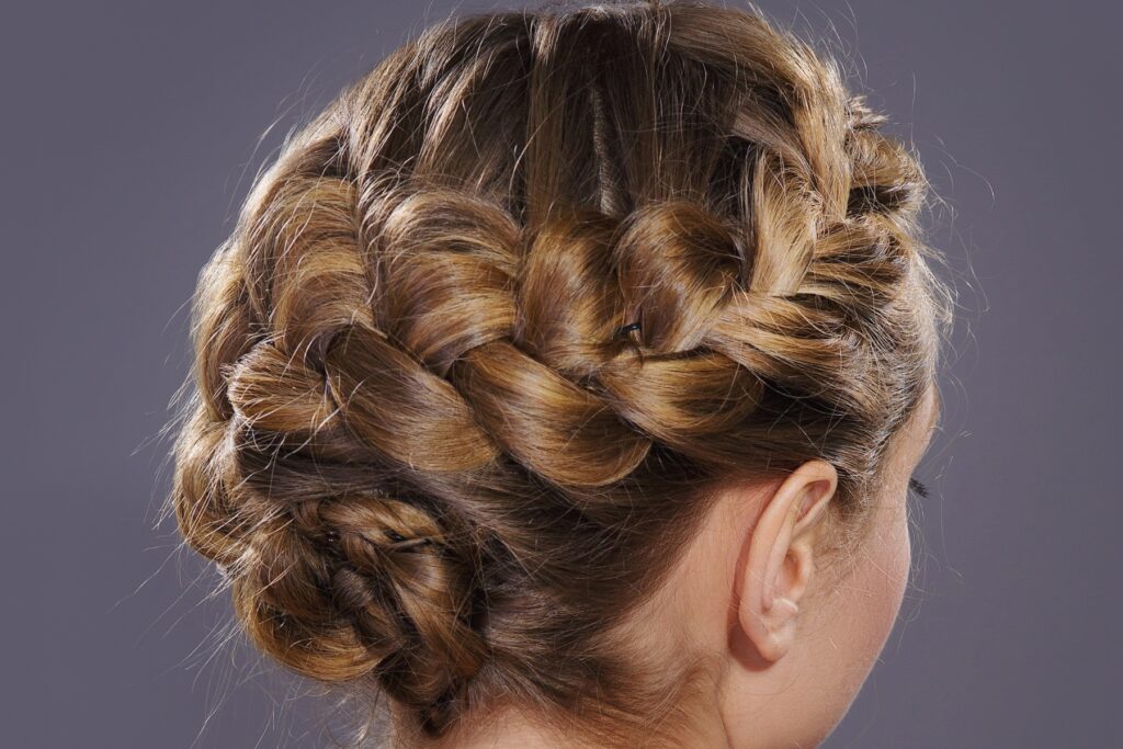 Elegante Hochsteckfrisur mit voluminösem, geflochtenem Kranz im Nacken.