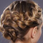 Elegante Hochsteckfrisur mit voluminösem, geflochtenem Kranz im Nacken.